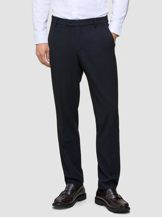 Atmungsaktive Motion Suit-Hose in Regular-Passform, mitternachtsblau, mit 360°-Stretch, kombiniert mit einem hellen Hemd und dunklen Loafern.