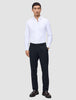 Ein Mann, der ein weißes Hemd, eine Motion Suit-Hose in der Passform Regular in Mitternachtsblau mit 360°-Stretch sowie dunkle Slipper trägt.