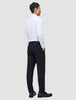 Ein Mann, von hinten gesehen, der ein weißes Hemd, Slipper und eine Motion Suit-Hose in der Passform Regular in Mitternachtsblau trägt.