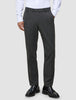 Eine Person, die eine Motion Suit Pants Regular Pepper Grey, ein weißes Hemd und schwarze Slipper trägt.