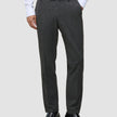Eine Person, die eine Motion Suit Pants Regular Pepper Grey, ein weißes Hemd und schwarze Slipper trägt.