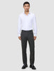 Ein Mann, der ein weißes Hemd, eine Motion Suit-Hose in der Passform Regular in der Farbe Pepper Grey und schwarze Anzugschuhe trägt.