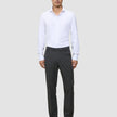 Ein Mann, der ein weißes Hemd, eine Motion Suit-Hose in der Passform Regular in der Farbe Pepper Grey und schwarze Anzugschuhe trägt.