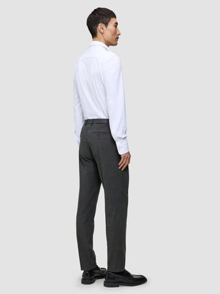 Ein Mann, von hinten gesehen, der ein weißes Hemd, eine Motion Suit-Hose in der Passform Regular in der Farbe Pepper Grey und schwarze Loafer trägt.