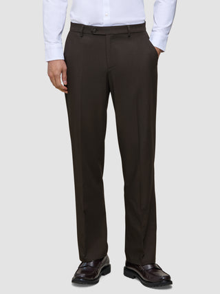 Eine Person, die ein weißes Hemd, eine Motion Suit-Hose in der Passform Relaxed in der Farbe Cognac und dunkelbraune Slipper trägt.