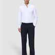 Ein Mann, der ein weißes Hemd und eine dunkelblaue Motion Suit-Hose im Relaxed-Schnitt in der Farbe Midnight Blue trägt.
