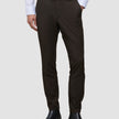 Eine Person, die ein weißes Hemd, eine schmal geschnittene, cognacfarbene Motion-Anzughose und schwarze Chelsea-Stiefel aus Leder trägt und damit einen eleganten Look präsentiert.