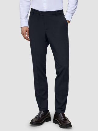 Motion-Anzughose, Slim-Fit, mitternachtsblau, kombiniert mit einem hellen Hemd und dunklen Loafern.