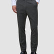 Eine Person, die ein weißes Hemd, eine Motion Suit-Hose in der Farbe Slim Pepper Grey und schwarze Leder-Loafer trägt.