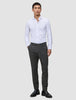Ein Mann, der ein weißes Hemd, eine Motion Suit-Hose in der Farbe Slim Pepper Grey und schwarze Slipper trägt.