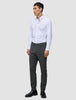 Ein Mann, der ein weißes Hemd, eine Motion Suit-Hose in der Farbe Slim Pepper Grey und schwarze Anzugschuhe trägt.