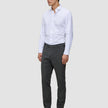 Ein Mann, der ein weißes Hemd, eine Motion Suit-Hose in der Farbe Slim Pepper Grey und schwarze Anzugschuhe trägt.