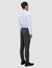 Ein Mann, von hinten gesehen, der ein weißes Hemd, eine Motion Suit-Hose in der Farbe Slim Pepper Grey und schwarze Slipper trägt.