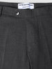 Nahaufnahme der Motion Suit-Hose Slim Pepper Grey in Dunkelgrau, mit schmaler Passform, Knopfverschluss und Markenetikett am Bund.