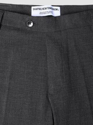 Nahaufnahme der Motion Suit-Hose Slim Pepper Grey in Dunkelgrau, mit schmaler Passform, Knopfverschluss und Markenetikett am Bund.
