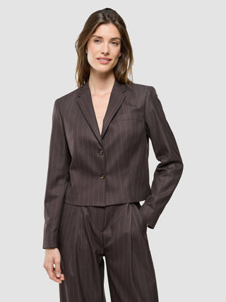 Eine Frau, die den Damen-Kurzblazer „Raina“ in der Farbe „Chestnut“ mit Nadelstreifen trägt.