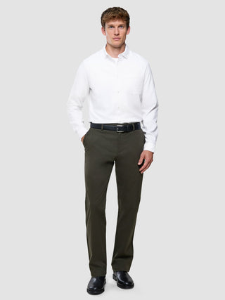 Ein Mann, der ein weißes Hemd, einen dunklen Gürtel und eine „Refine Cotton Pants Relaxed Fit Dark Olive“ trägt.
