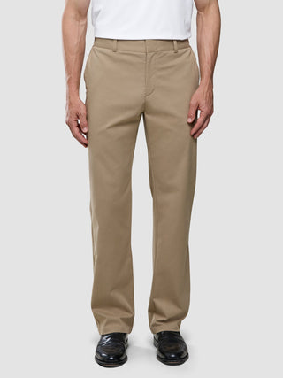 Eine Person, die ein weißes T-Shirt und eine „Refine Cotton Pants Relaxed Fit Sand“ trägt.