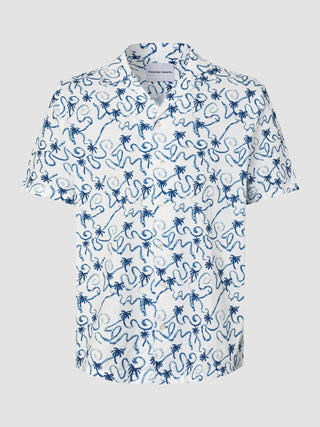 Seersucker-Kurzarmhemd „Navy Palms“ mit Bowlingkragen, weißem Grund und einem blauen, handgezeichneten Aufdruck mit Palmen und Wellenlinien.