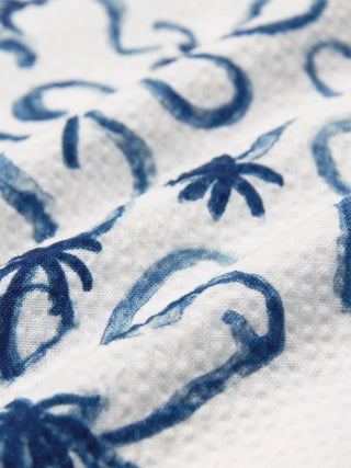 Seersucker-Kurzarmhemd „Navy Palms“ mit einem blauen, handgemalt anmutenden Palmenmuster und einem Bowlingkragen.