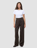 Eine Person, die ein weißes T-Shirt und eine weit geschnittene Serene Pants Wide Walnut Herringbone mit vertikalen Nadelstreifen trägt.