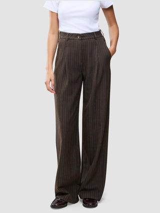 Dunkelbraune Serene-Hose mit hoher Taille im Wide Walnut Herringbone-Muster, mit feinen vertikalen Nadelstreifen und weitem Beinschnitt, kombiniert mit einem weißen T-Shirt.