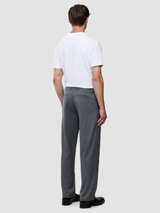 Ein Mann, von hinten gesehen, der ein weißes T-Shirt und eine „Siena Pants Relaxed Fit Herringbone Grey“ trägt.