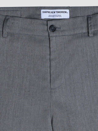 Nahaufnahme der grauen Siena-Hose im Fischgrätenmuster in Relaxed Fit mit einem „Shaping New Tomorrow“-Markenlabel im Bund.