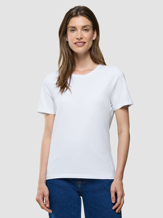 Eine Frau, die ein weißes Supima-T-Shirt und eine blaue Jeans trägt.