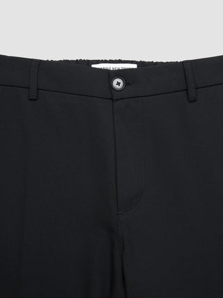 Nahaufnahme des Bunds und des Knopfverschlusses der „Tech Linen Elastic Pants Black“.