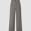 Damenhose Ashryn Wide Domino Herringbone: Eine hoch taillierte Hose mit weitem Bein aus schwarz-weißem Bouclé im Fischgrätenmuster, mit Falten auf der Vorderseite, Knopfverschluss und einem schlichten, skandinavisch inspirierten Design.
