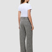 Eine Person, von hinten gesehen, die ein weißes T-Shirt und eine graue, hoch taillierte Hose mit weitem Bein der Marke Women Ashryn Pants Wide Domino Herringbone trägt.