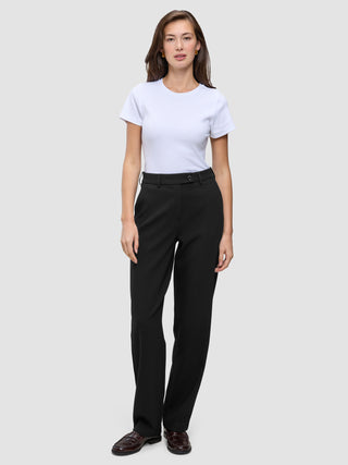 Eine Frau, die ein weißes T-Shirt und eine Women GO2 Pants Straight Black mit geradem Bein trägt.