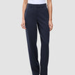 Eine Person trägt ein weißes T-Shirt, das in die Women GO2 Pants Straight Blue Nights mit Knopfverschluss gesteckt ist, dazu dunkelbraune Schuhe im minimalistischen skandinavischen Design.