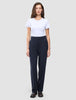 Eine Frau in einem weißen T-Shirt und einer Women GO2 Pants Straight Blue Nights in Dunkelblau mit geradem Schnitt, die das minimalistische skandinavische Design widerspiegelt.