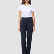Eine Frau in einem weißen T-Shirt und einer Women GO2 Pants Straight Blue Nights in Dunkelblau mit geradem Schnitt, die das minimalistische skandinavische Design widerspiegelt.