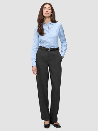 Eine Frau trägt ein hellblaues Hemd, das in eine Women GO2 Pants Straight Dark Grey Melange gesteckt ist, dazu einen schwarzen Gürtel – ein Beispiel für klares skandinavisches Design.