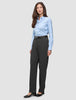 Eine Frau, die ein hellblaues Hemd trägt, das in eine Women GO2 Pants Straight Dark Grey Melange gesteckt ist, dazu einen schwarzen Gürtel und schwarze Pumps – ein klares, skandinavisches Design.
