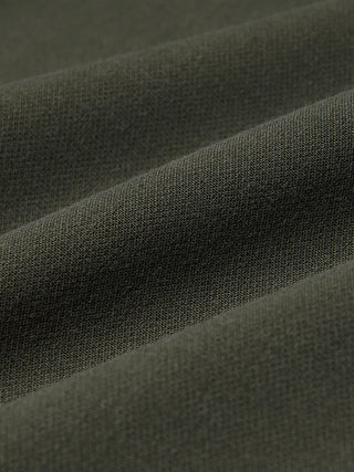 Nahaufnahme der Women GO2 Pants Straight Dusty Olive aus olivgrünem Doubleface-Stoff mit den für skandinavisches Design charakteristischen diagonalen Falten.