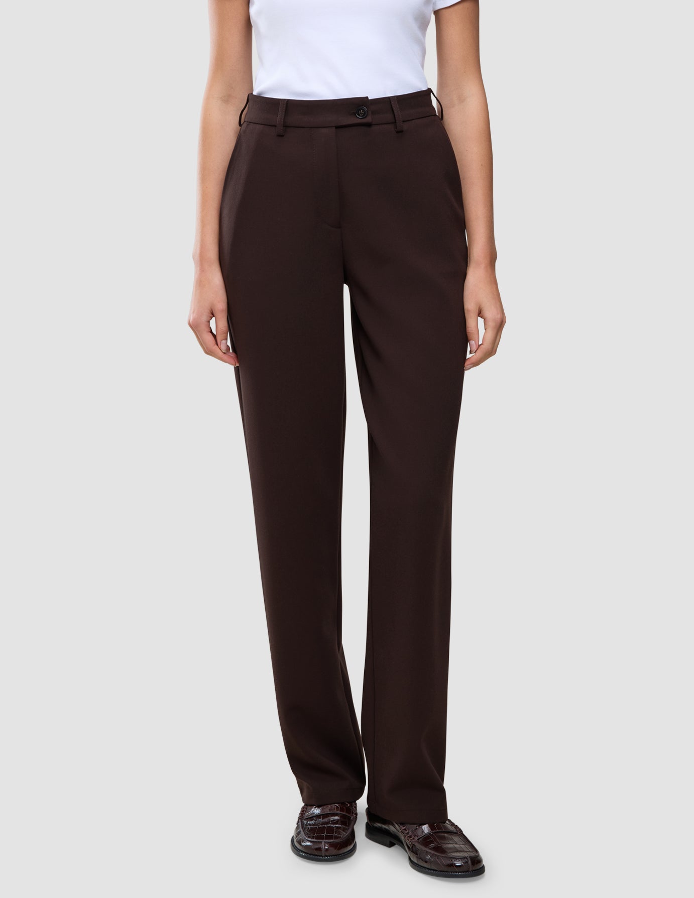 Eine Person, die eine dunkelbraune Women GO2 Pants Straight Mocha aus Doubleface-Material trägt, dazu passende dunkelbraune Loafer.