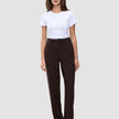 Eine Person, die ein weißes T-Shirt und die Hose Women GO2 Pants Straight Mocha in Dunkelbraun trägt, die sich durch ein schlichtes, skandinavisches Design auszeichnet.