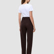 Eine Frau, von hinten gesehen, die ein weißes T-Shirt trägt, das in eine dunkelbraune Women GO2 Pants Straight Mocha mit hoher Taille und geradem Beinschnitt gesteckt ist.