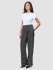 Eine Frau, die ein schlichtes weißes T-Shirt und die Women Nara Pants Wide Black Check trägt, die schwarz sind und ein dezentes graues Karomuster aufweisen.