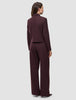 Eine Person, von hinten gesehen, trägt die kurze Damenjacke Serene in der Farbe Berry Pinstripe mit kastenförmiger Passform sowie eine dazu passende Hose mit weitem Bein im skandinavischen Stil.