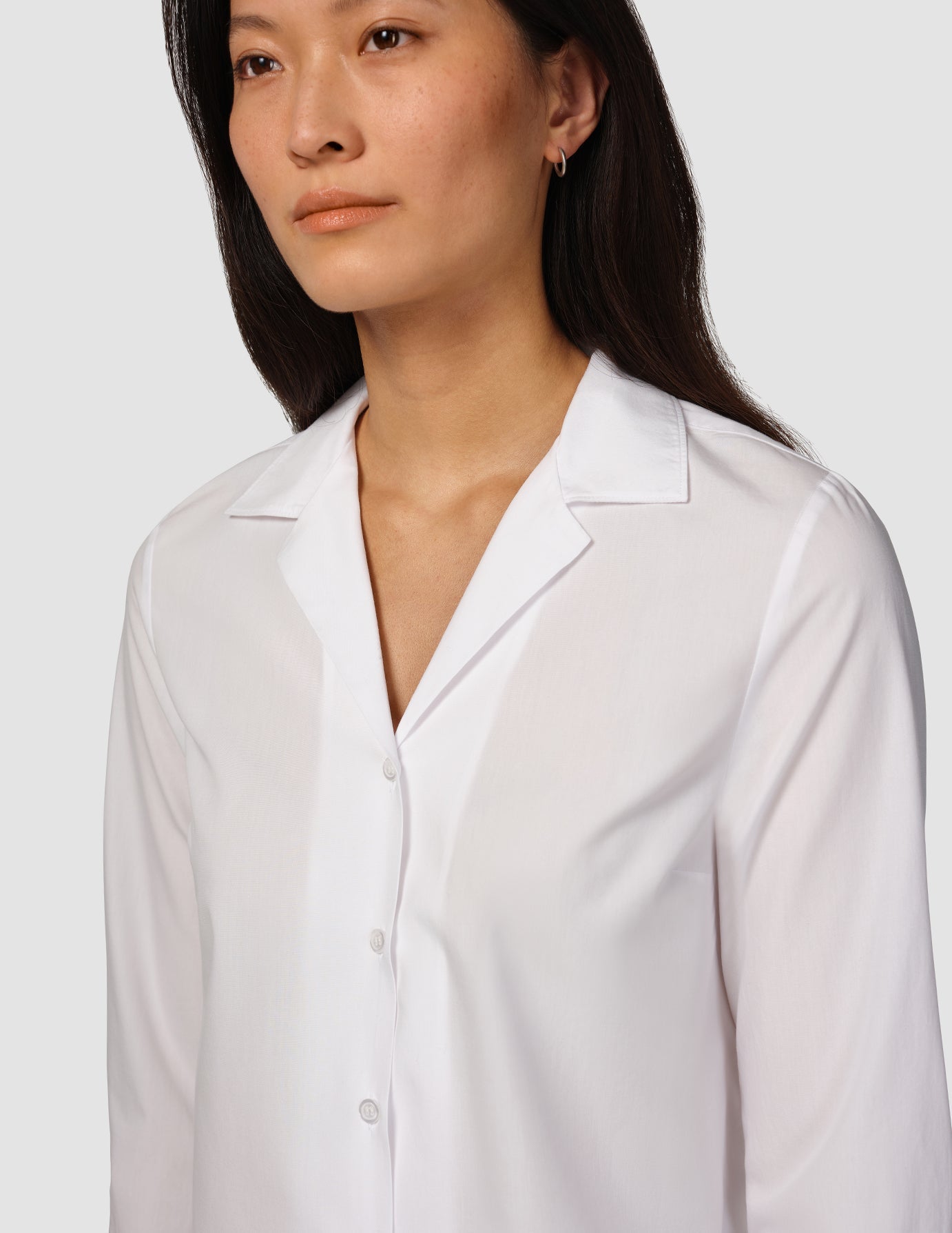 Eine Frau, die ein „Madison Shirt White“ aus 100 % Baumwolle trägt.
