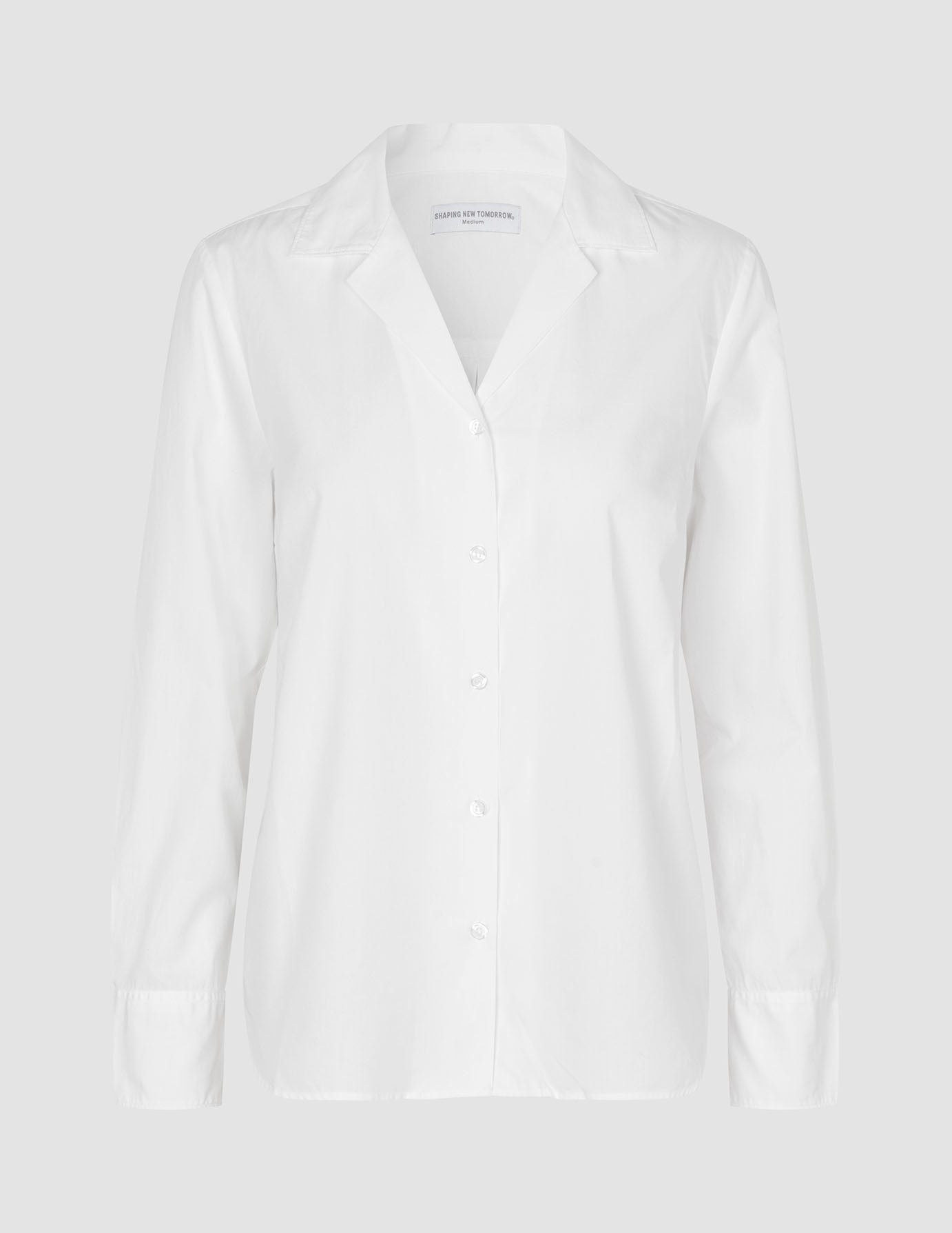 Ein weißes „Madison Shirt White“ von Shaping New Tomorrow aus 100 % Baumwolle mit gekerbtem Kragen und langen Ärmeln.