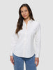 Eine Frau, die ein weißes Damen-Oxford-Hemd White Orchid Slim mit klassischem Kragen und eine blaue Jeans trägt.
