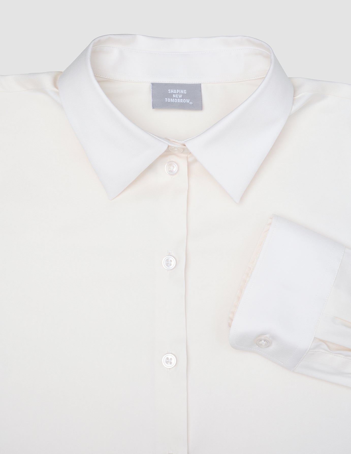 Cremefarbenes, langärmeliges Damen-Oxfordhemd White Orchid Slim mit klassischem Kragen und umgeschlagenen Manschetten im minimalistischen skandinavischen Design.