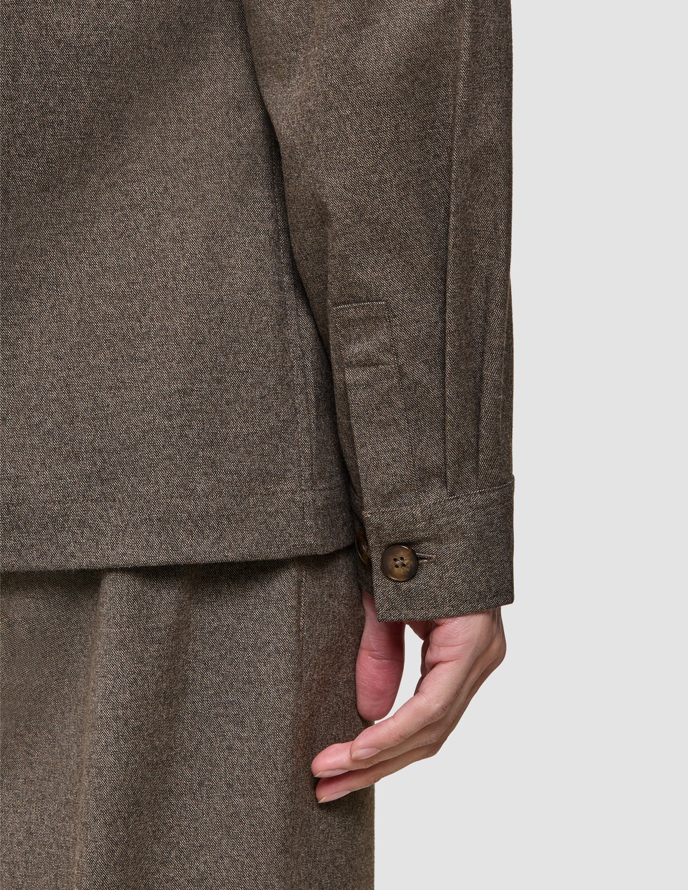 Nahaufnahme eines Ärmels des Atelier Overshirt Dark Beige mit gebrochenem Köpermuster und geknöpftem Ärmelbund.