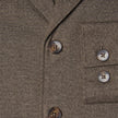 Nahaufnahme eines Atelier Overshirt in Dunkelbeige mit gebrochener Köperbindung, gekerbtem Revers, Brusttasche und dunklen Knöpfen.